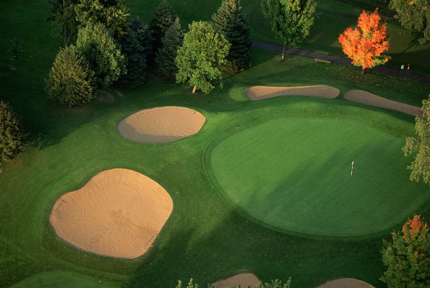 Sand traps surround a putting green on the golf course at the Interlachen Country Club.  Edina, Minnesota.